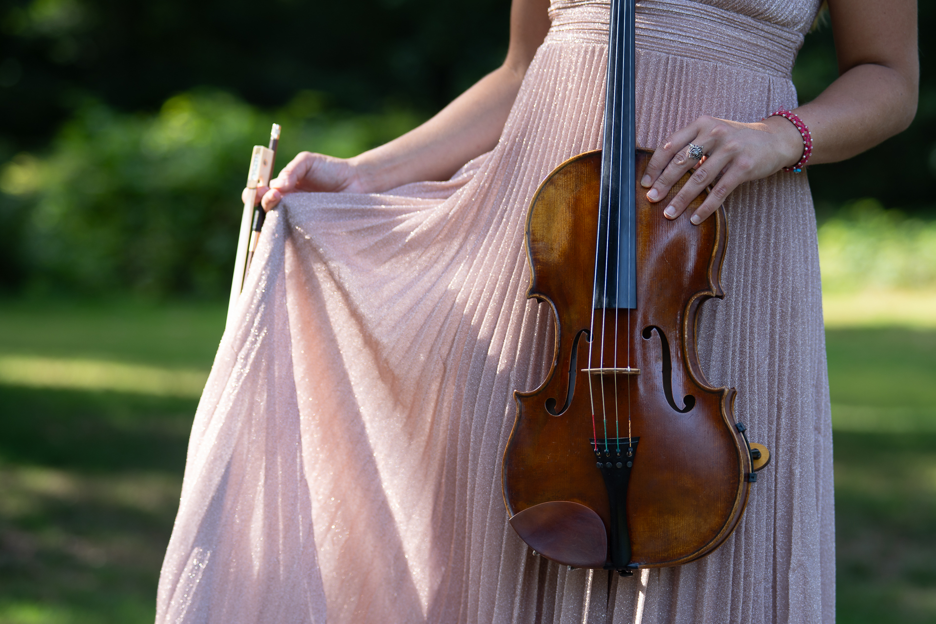Violist buiten in Lumiere-jurk.