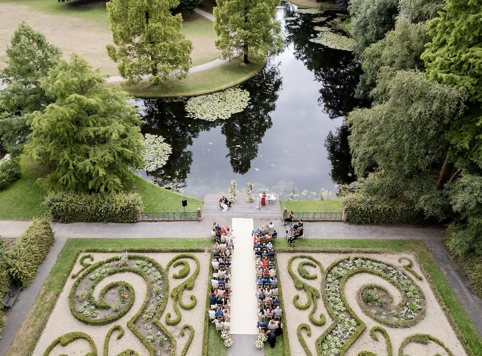bruiloft ceremonie op landgoed buiten aan het water met gasten en strijkkwartet